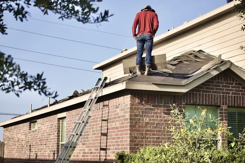 Professional roofer working on a residential roof in Hood